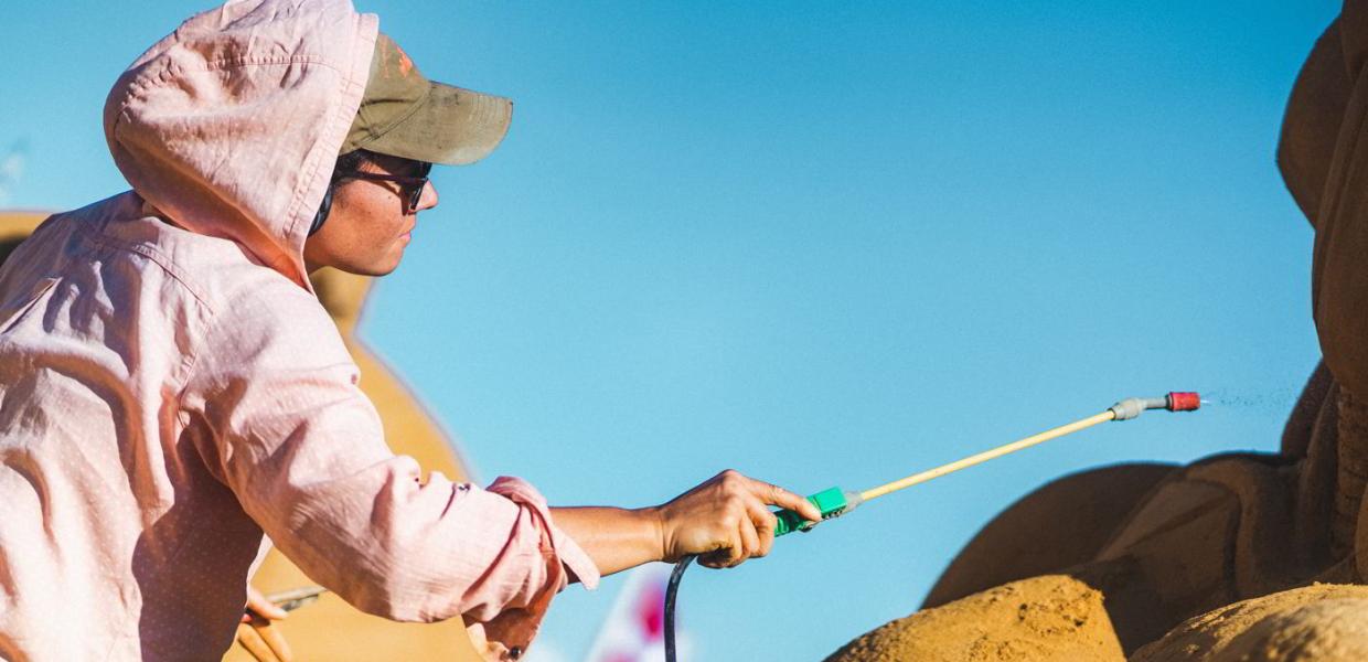 En skulptør er ved at bygge en sandskulptur i Hundested Sandskulptur Park